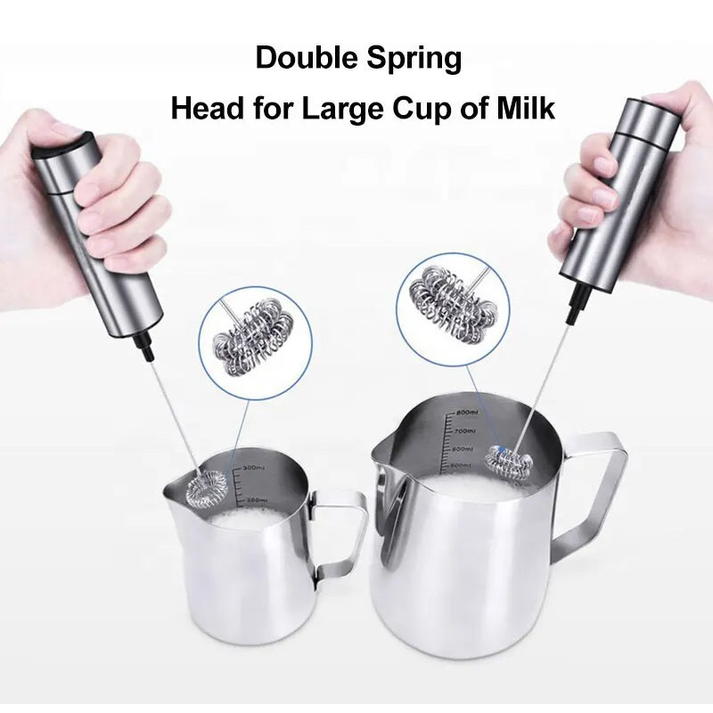 Electric milk frother with double spring whisk head shown with two stainless steel milk pitchers
